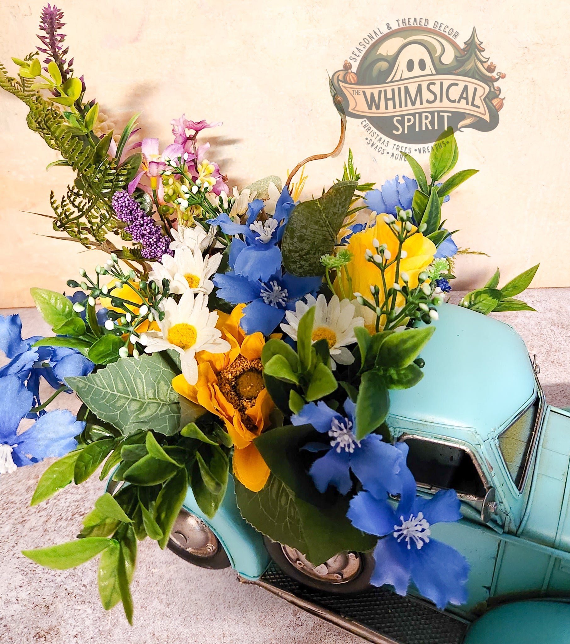 Vintage teal truck with a large bouquet of colorful flowers, featuring the 'Whimsical Spirit' brand.