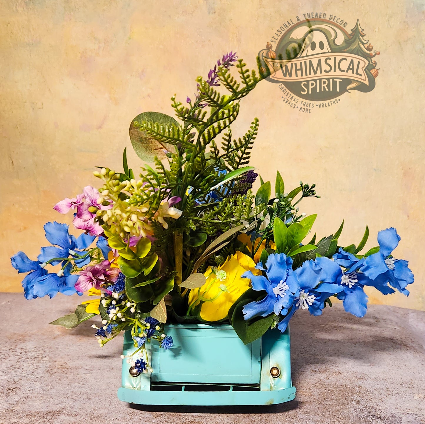 Decorative flower arrangement in a teal container with 'Whimsical Spirit' branding in the background.