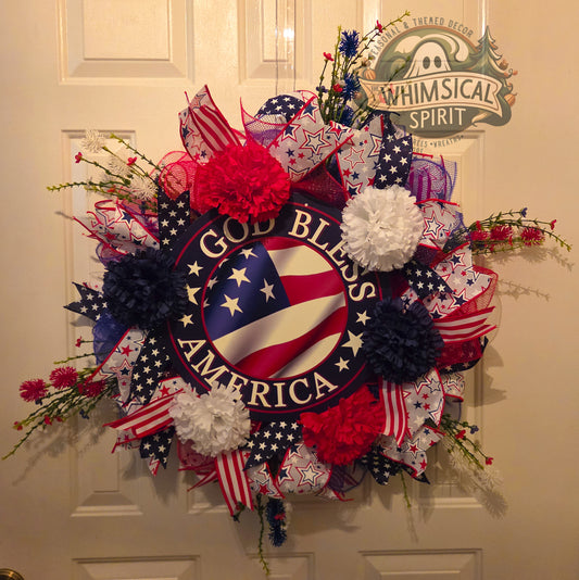 Decorative wreath with 'God Bless America' text and American flag design on a door.