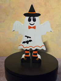 Front view of wooden Halloween ghost shelf sitter wearing a black witch hat, orange bow tie, striped legs, and bat accents.