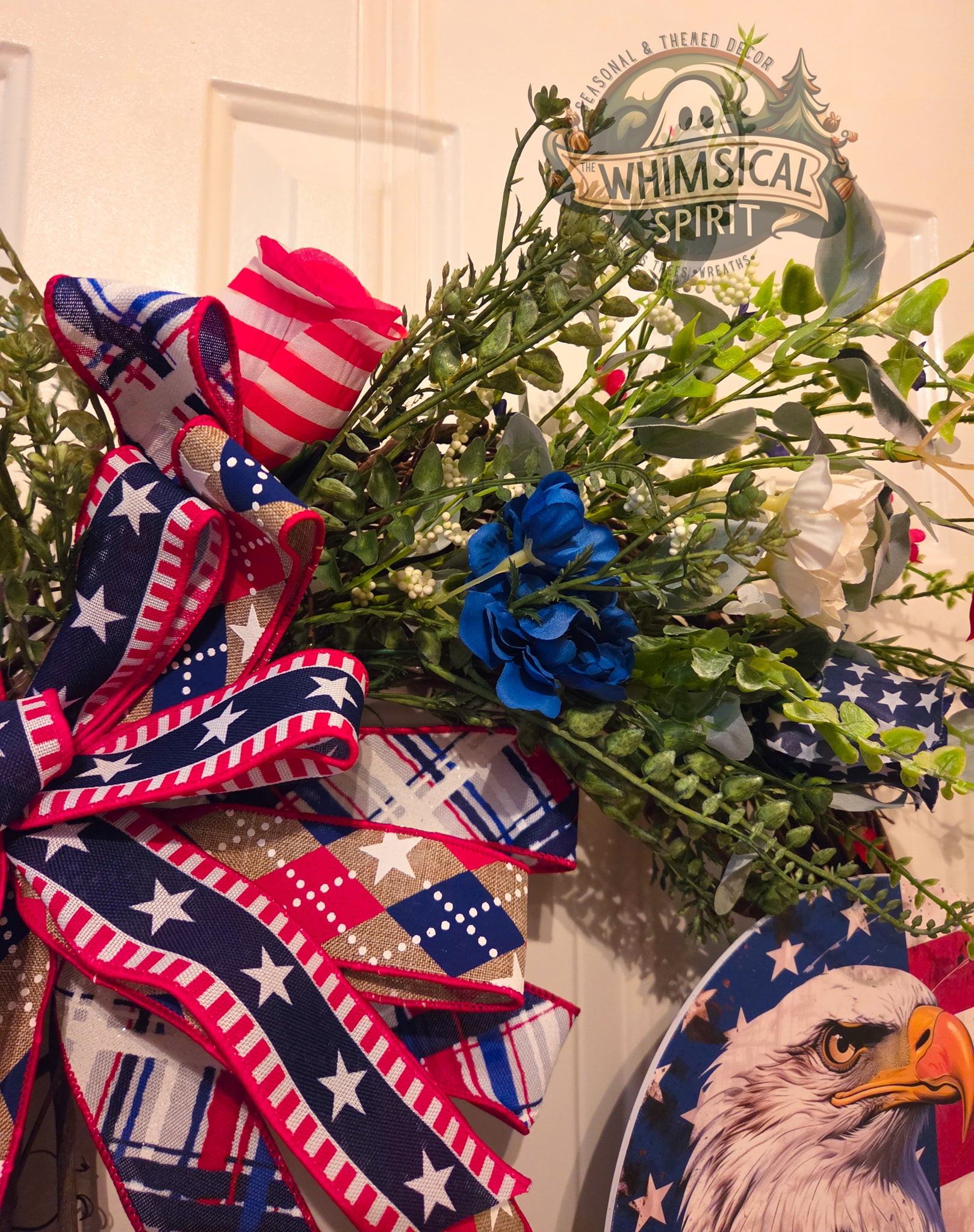 Decorative wreath with American flag-themed ribbons and a 'Whimsical Spirit' sign in the background.