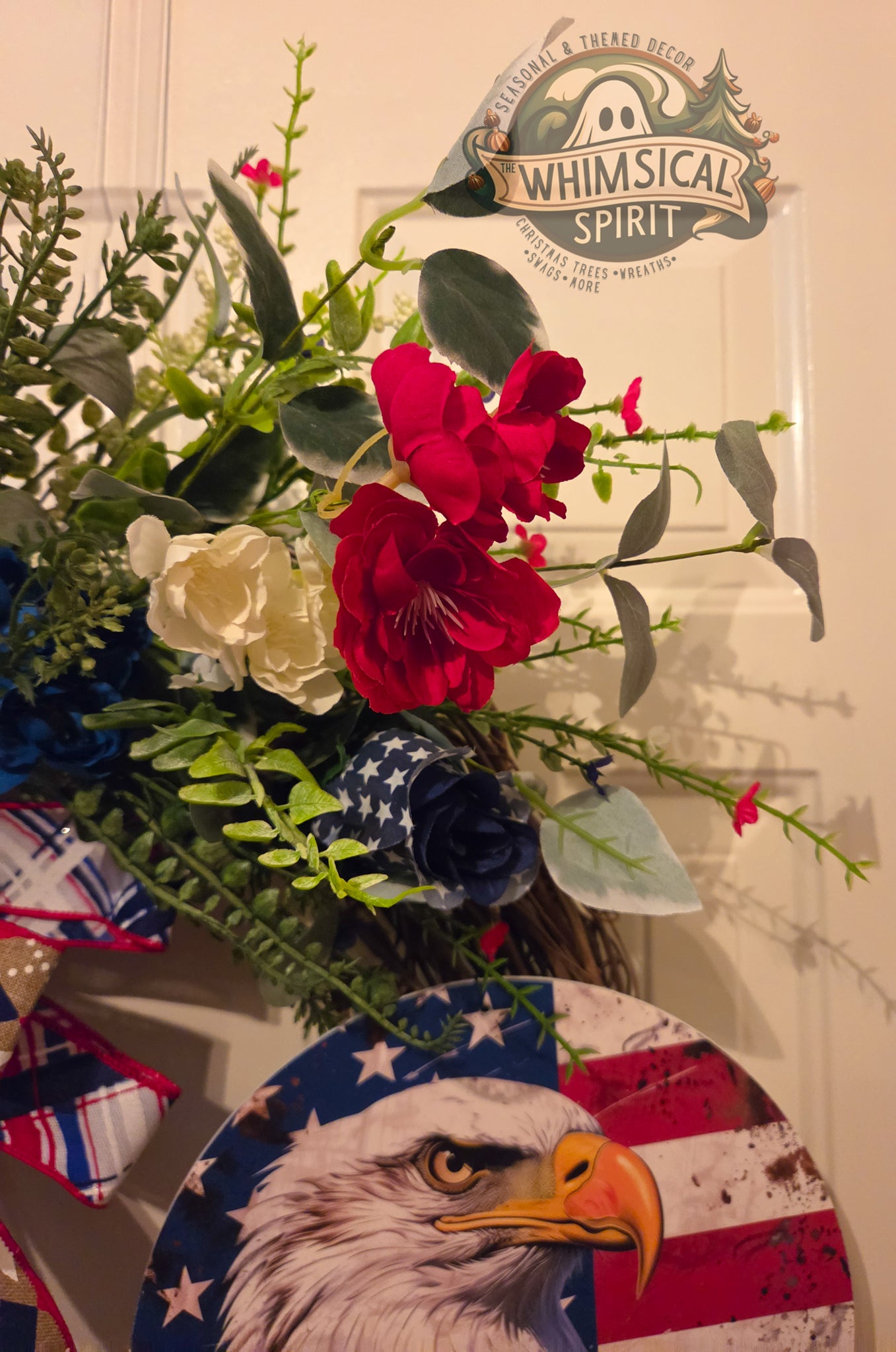 Decorative wreath with flowers and an American flag design featuring an eagle, branded 'Whimsical Spirit'.