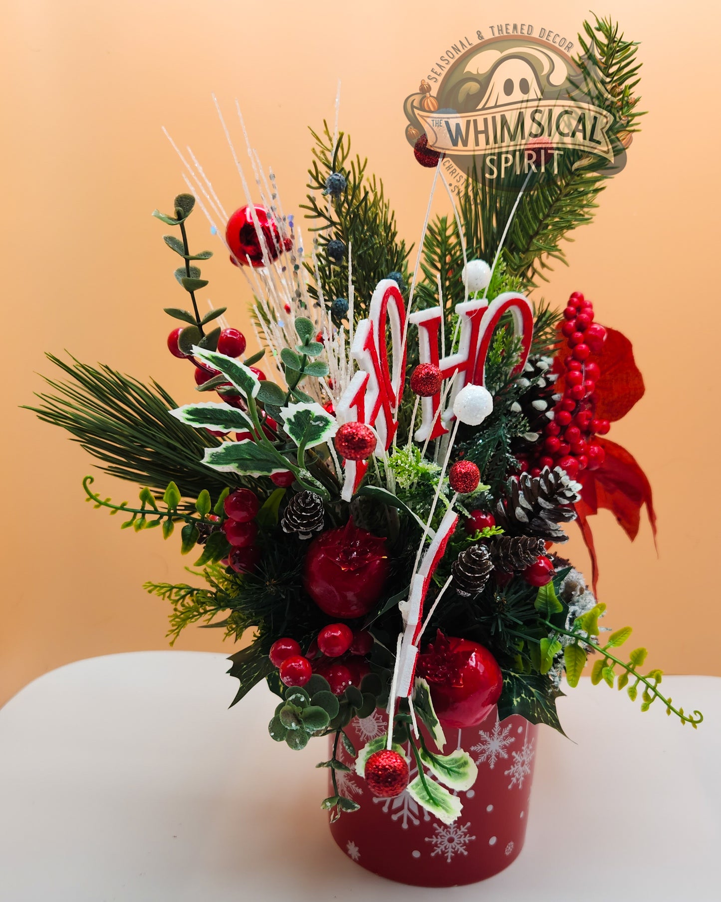 Decorative Christmas flower arrangement with candy canes and red berries in a red vase on a beige background.