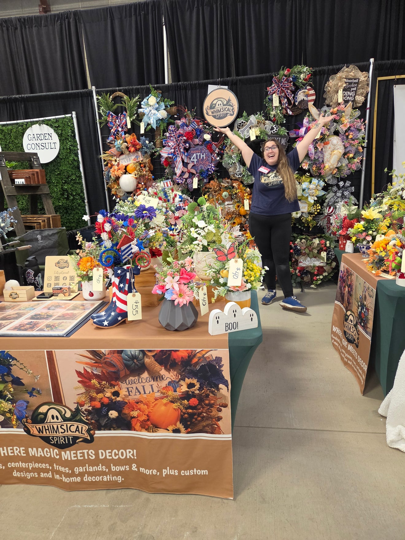 The Whimsical Spirit market booth filled with handmade wreaths, centerpieces, bows, seasonal decor, and custom home accents at a local Arizona event.