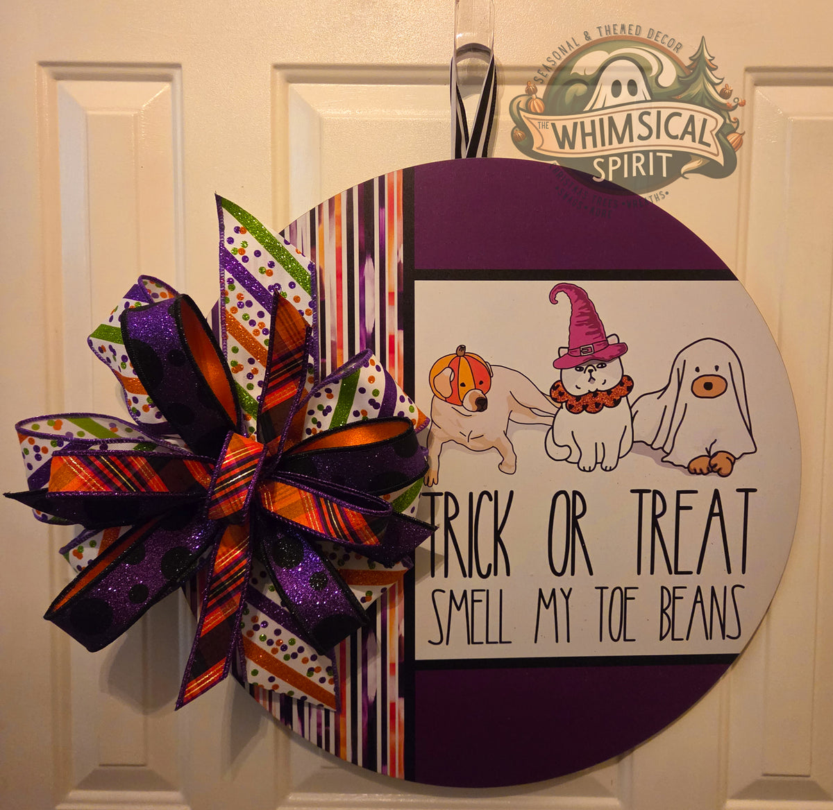 Round Halloween pet door hanger with three costumed animals, a purple striped design, funny toe-beans message, and colorful layered bow.
