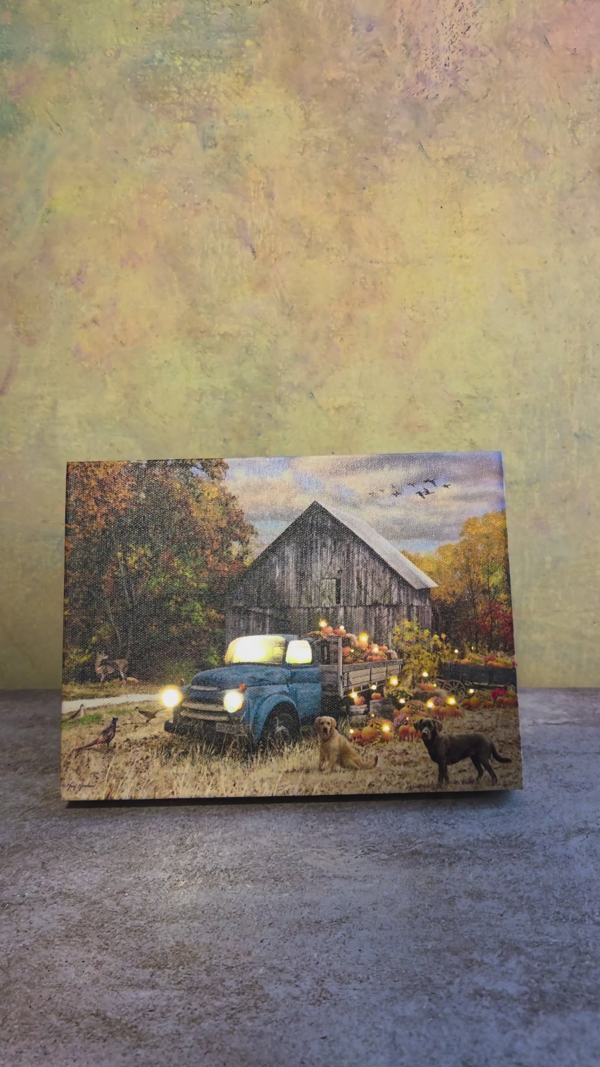 Video showing the light-up function on Harvest Day, a fall tabletop canvas featuring a blue truck, pumpkins, rustic barn, autumn trees, dogs, and cozy harvest details.