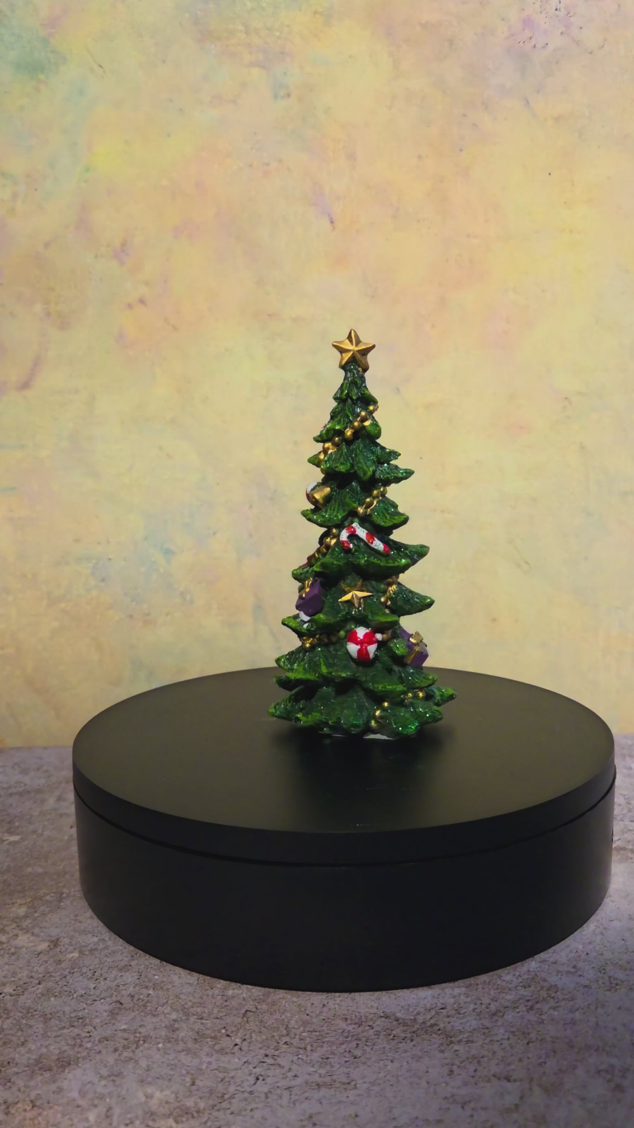 Turntable video showing all sides of the extra small decorated resin Christmas tree figurine with traditional holiday accents.