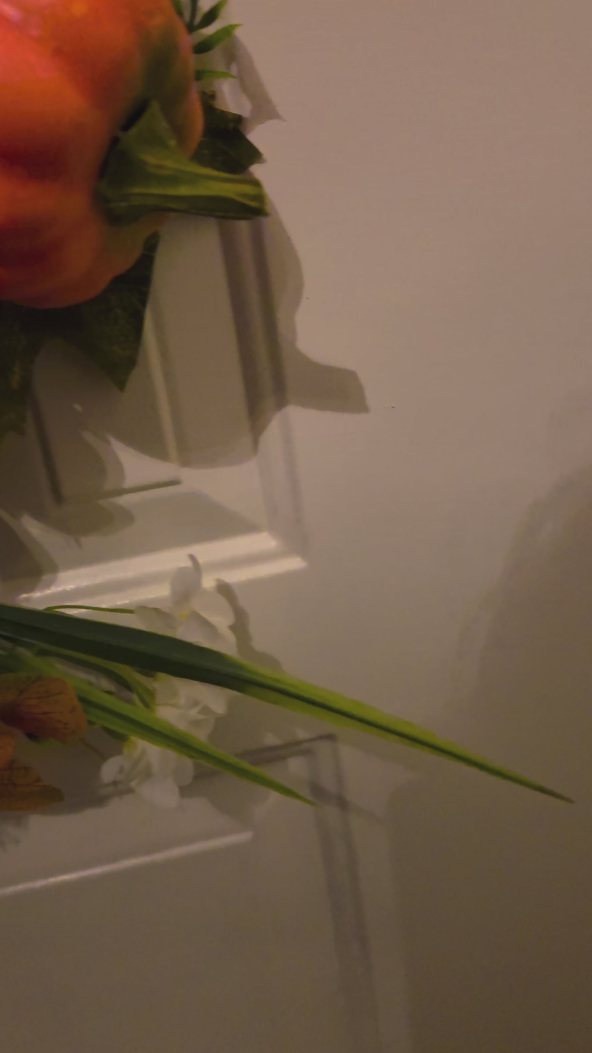 Closeup video of a handmade fall pumpkin floral door hanger, showing the Hello Pumpkin sign, layered bow, pumpkin accents, orange florals, and autumn greenery before panning out to reveal the full design.