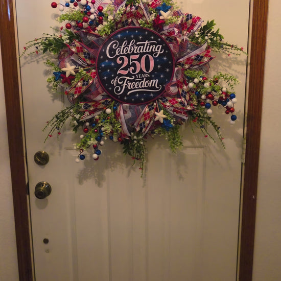 Decorative wreath in a variety of colors with an image of celebrating 250 years of freedom on it for July 4th