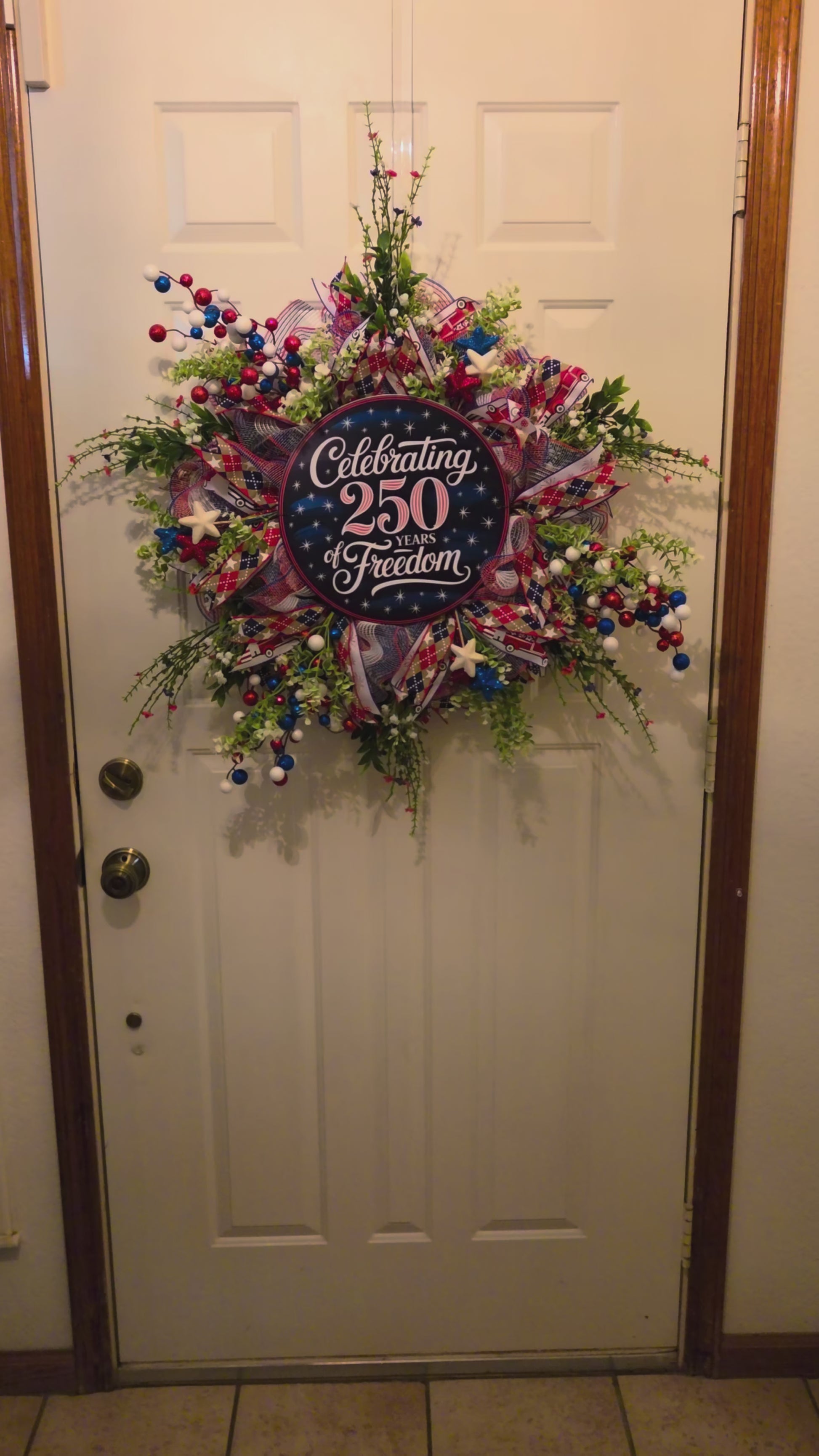 Decorative wreath in a variety of colors with an image of celebrating 250 years of freedom on it for July 4th