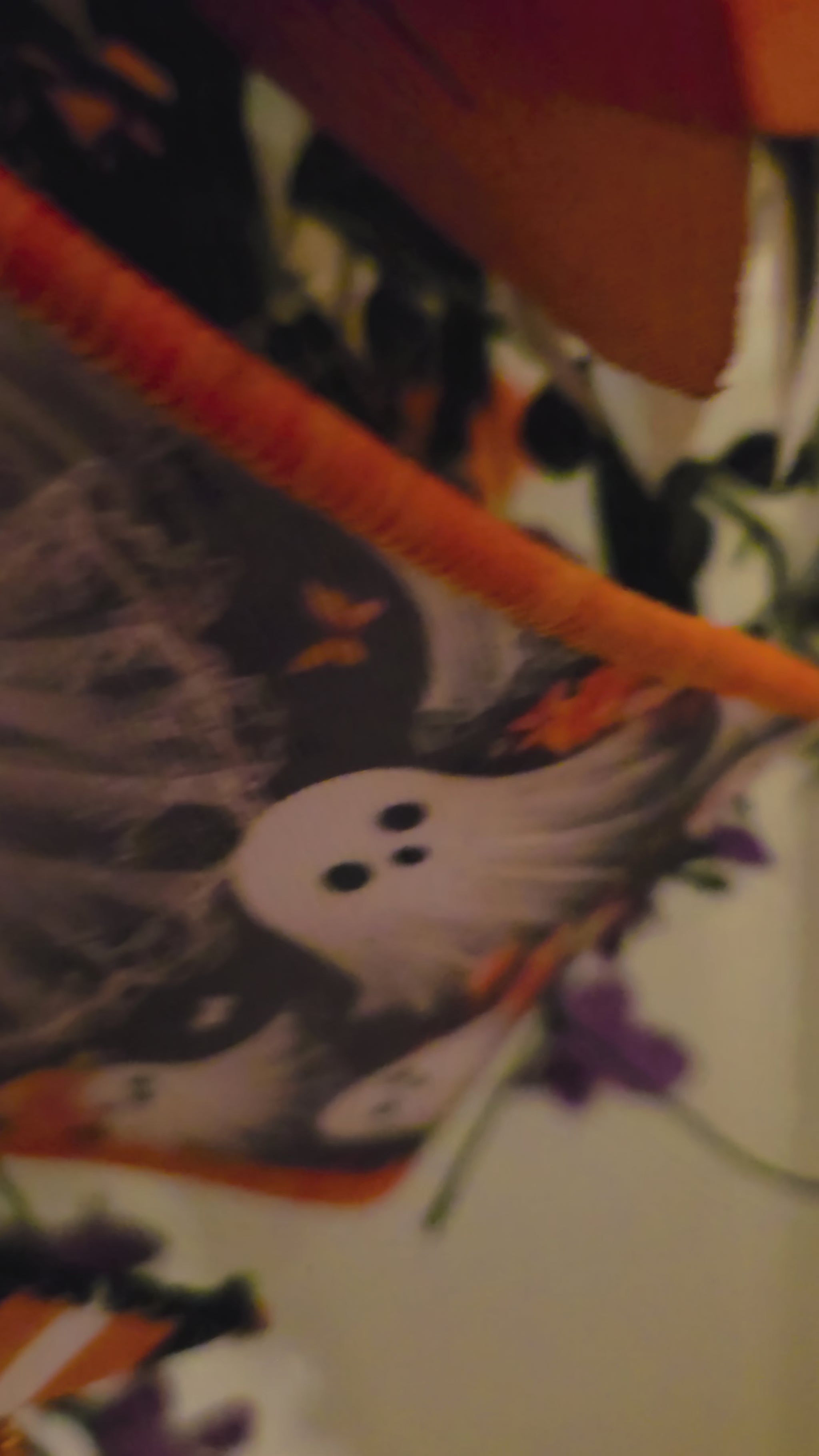 Video moves through close-up views of the Boo sign, Halloween ribbons, orange and purple foliage, and decorative details before revealing the full ghost wreath.