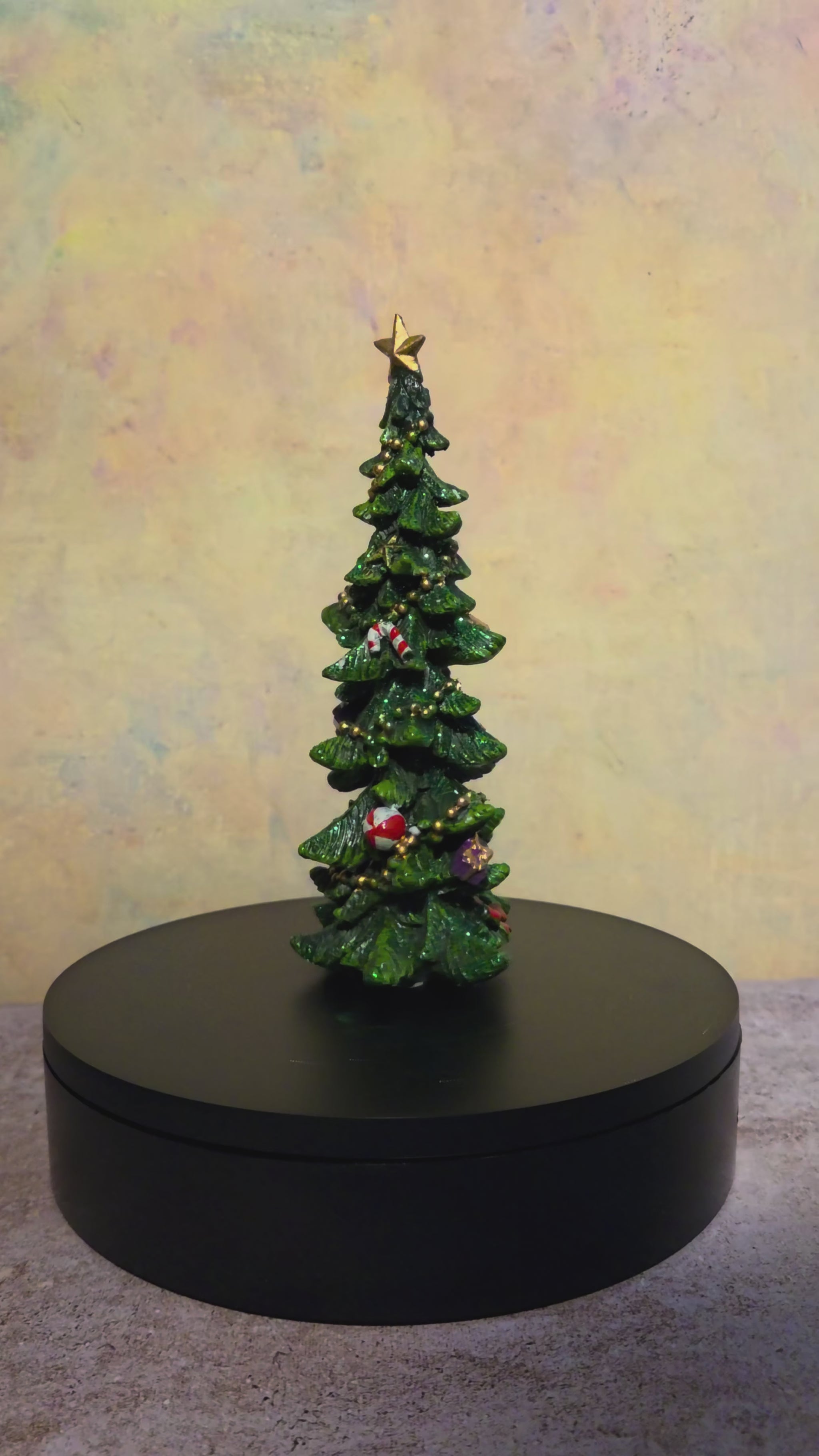 Turntable video showing the small resin Christmas tree tabletop decoration from multiple angles.
