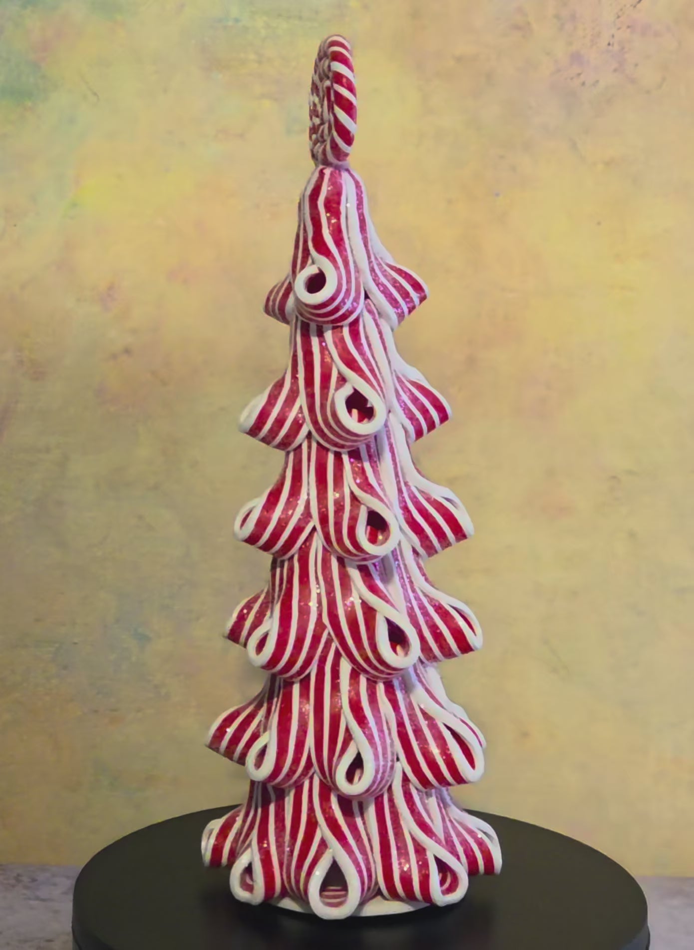 Short turntable video showing the short Peppermint Twirl Trees rotating to display their red-and-white ribbon design, candy toppers, and lighted details.
